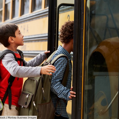 Kids boarding school bus | Shutterstock, Monkey Business Images